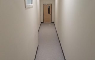 white hallway with wooden door